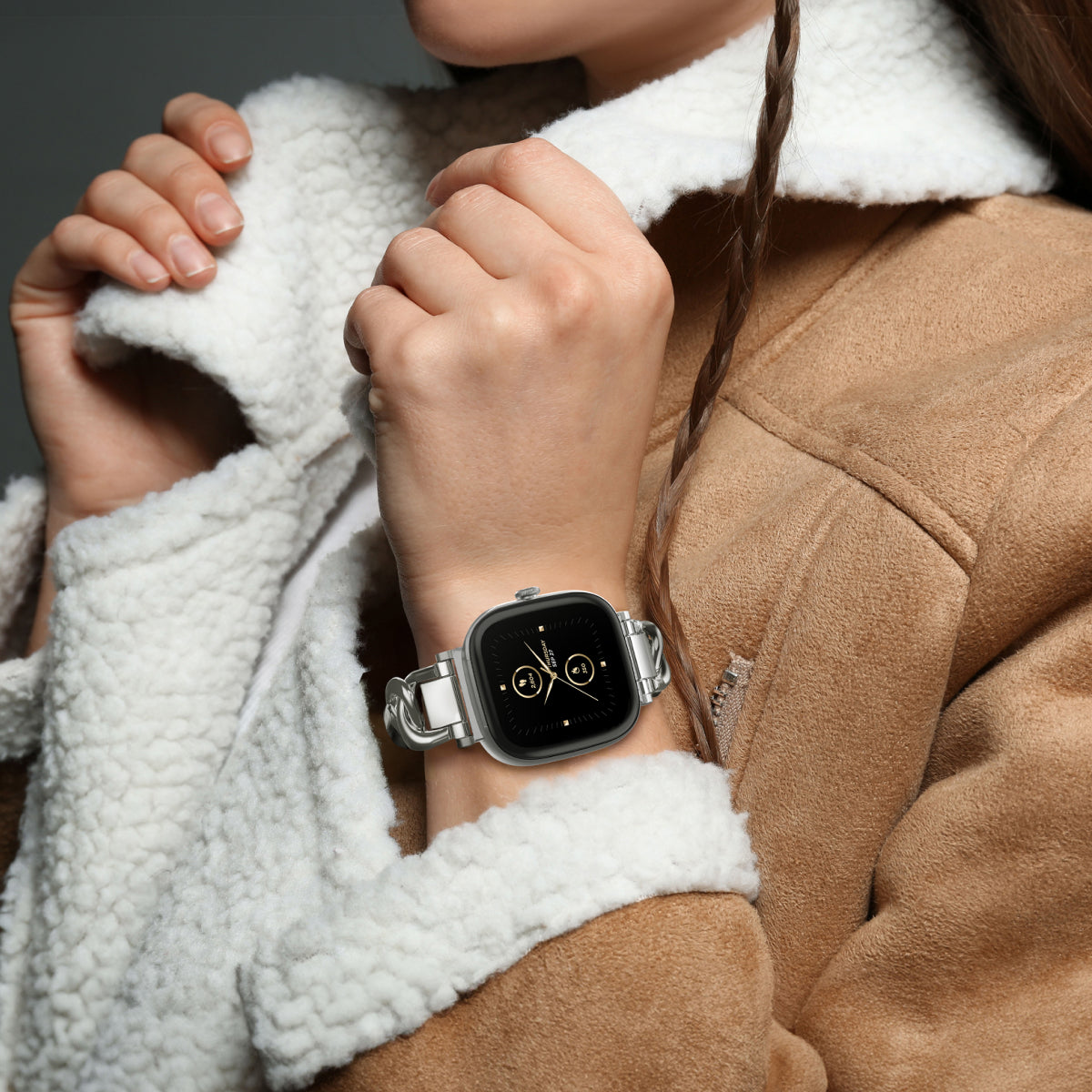Person wearing a smartwatch with a neutral background