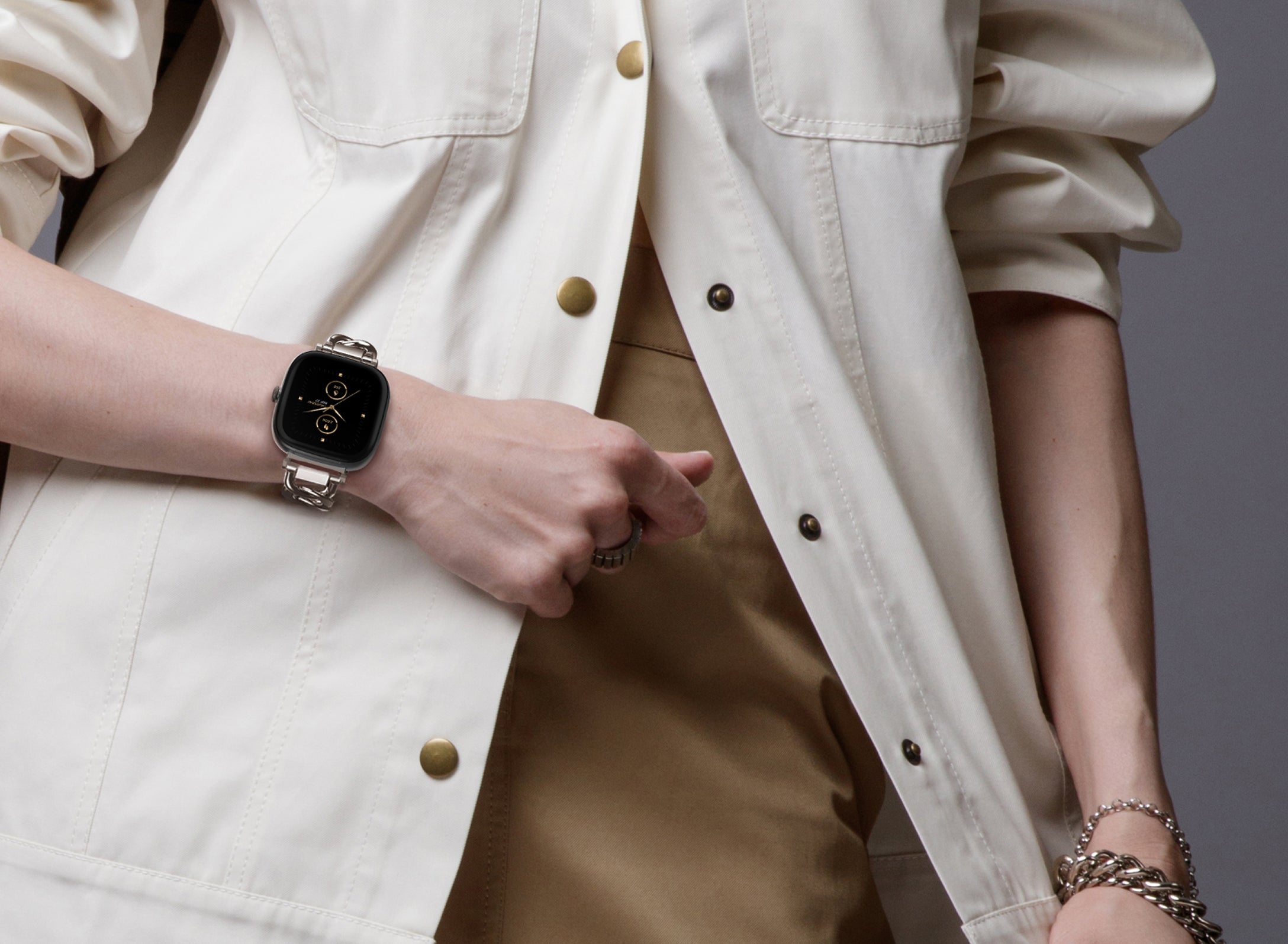 Person wearing a smartwatch with a neutral background